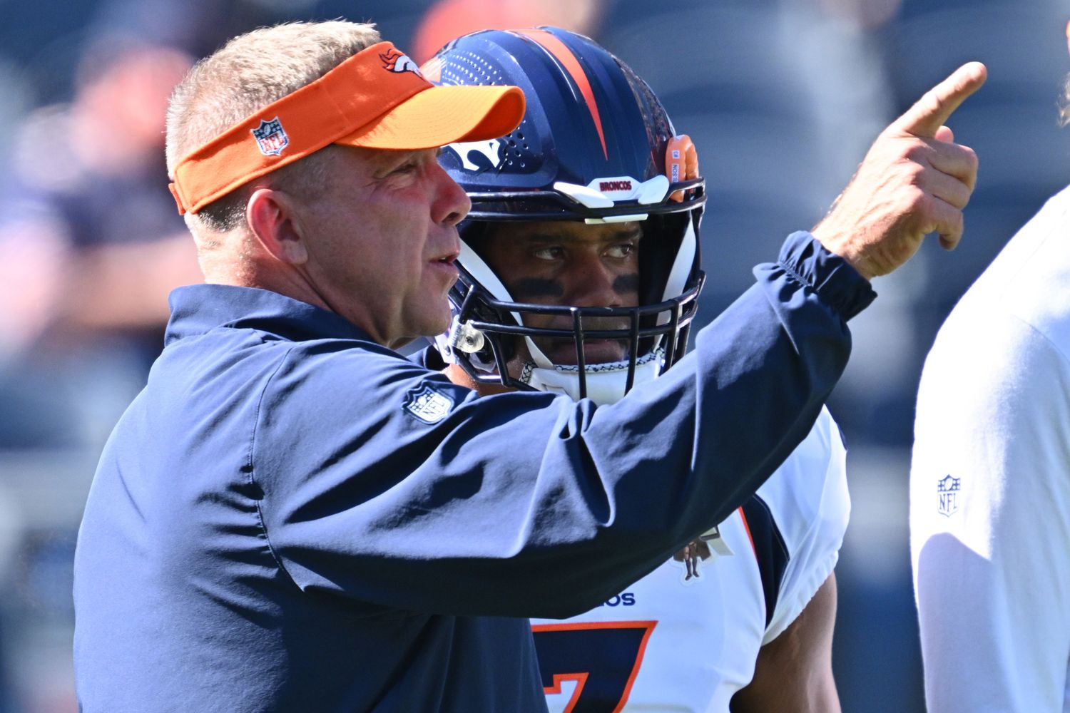 Broncos' QB Russell Wilson speaks with head coach Sean Payton